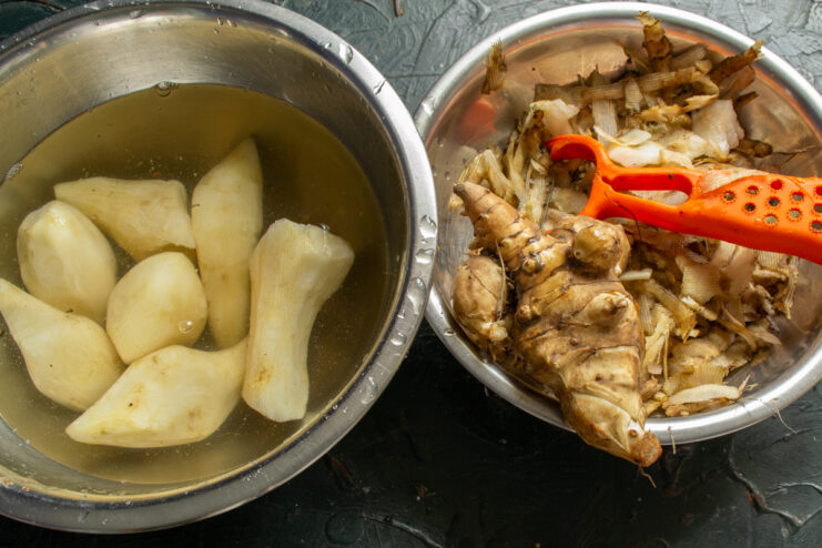 Prepping the Jerusalem artichokes Peeling Jerusalem artichoke tubers with a vegetable peeler