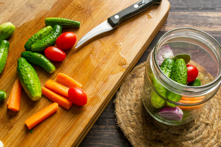 Cucumbers and cherry tomatoes packed into a jar with spices