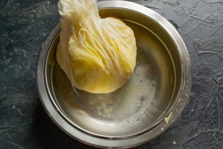 Squeezing moisture from grated potatoes Squeezing excess liquid from grated potatoes using cheesecloth
