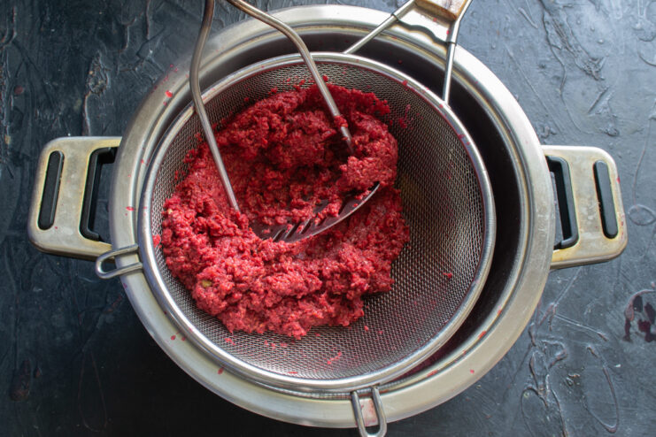 Extracting the raspberry juice Pressing raspberry pomace through a sieve