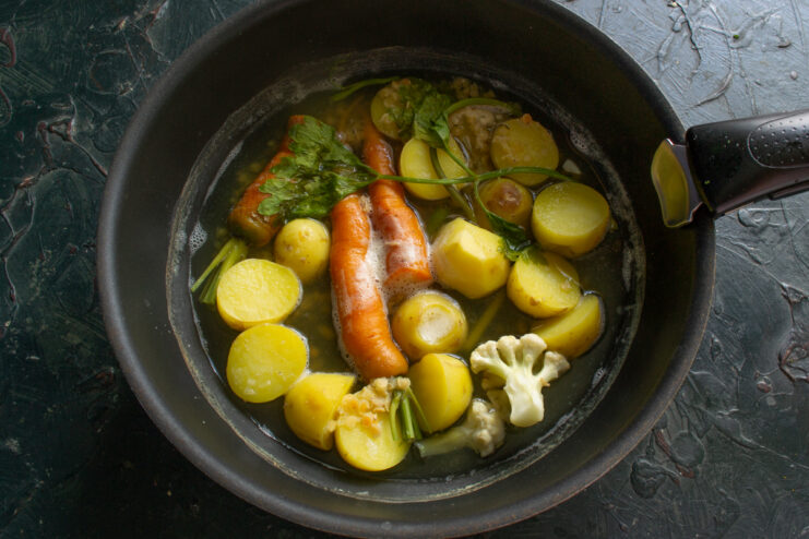 Cooking the vegetable base Vegetables and fresh herbs gently boiling in clear fish broth