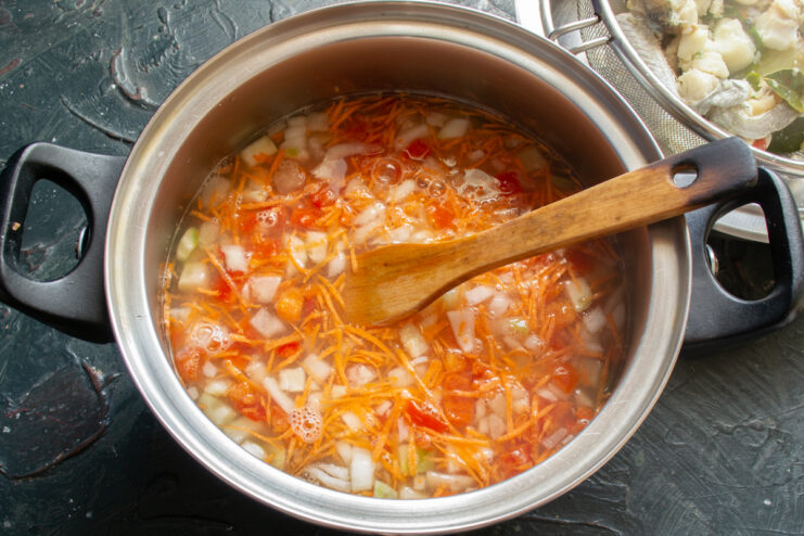 Pouring Broth Over the Vegetables Vegetables in a pot submerged in clear fish broth