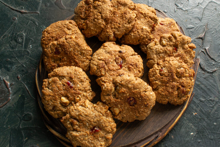 Finished results Cooled oatmeal cookies with cranberries and nuts on a wooden board