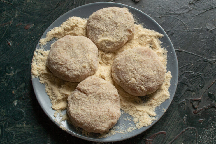 Chilling the breaded patties Breadcrumb-coated meat patties arranged on a gray plate