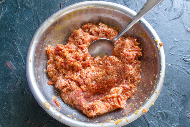Mixing The Filling Mixed sausage filling with spices and oil in a bowl