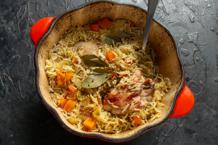 Final look of the plov Mixed finished chicken plov with carrots in a cast iron Dutch oven