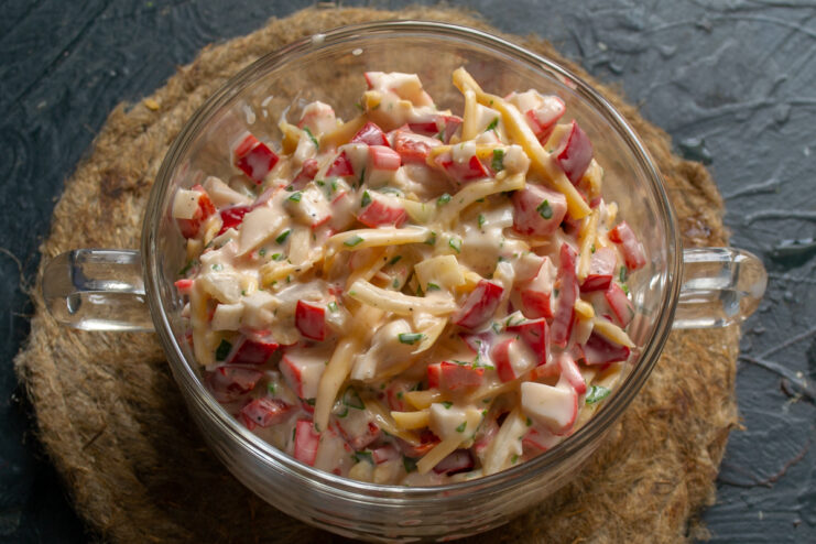 Mixing The Salad Mixed crab stick salad in a clear glass bowl