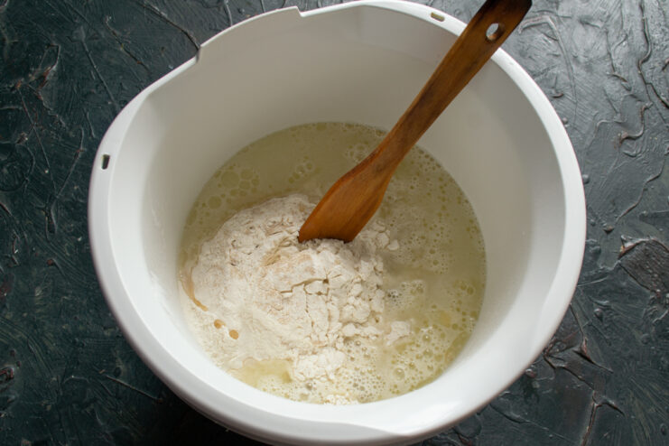 Equalizing ingredient temperature Mixing pizza dough ingredients in a bowl with a spatula