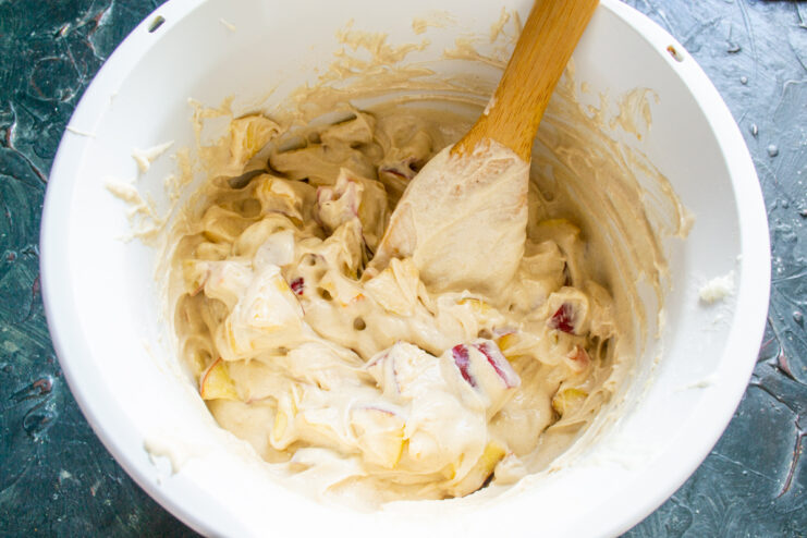 Folding in the apples Mixing apples into the batter with a spatula