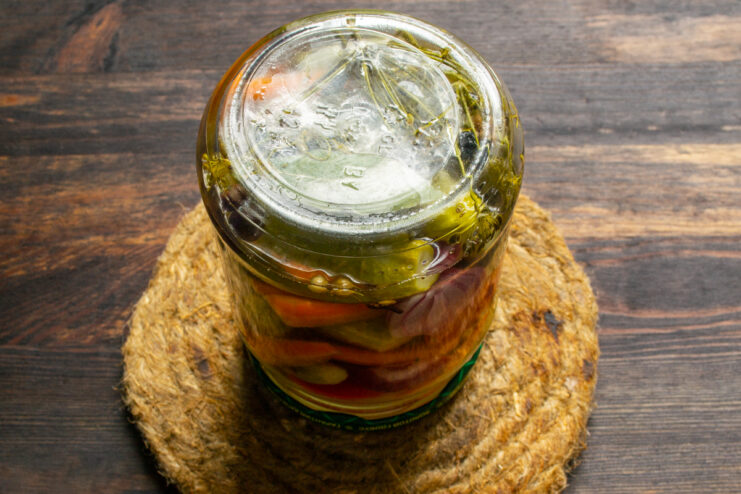 An upside-down jar of pickles resting on a stand
