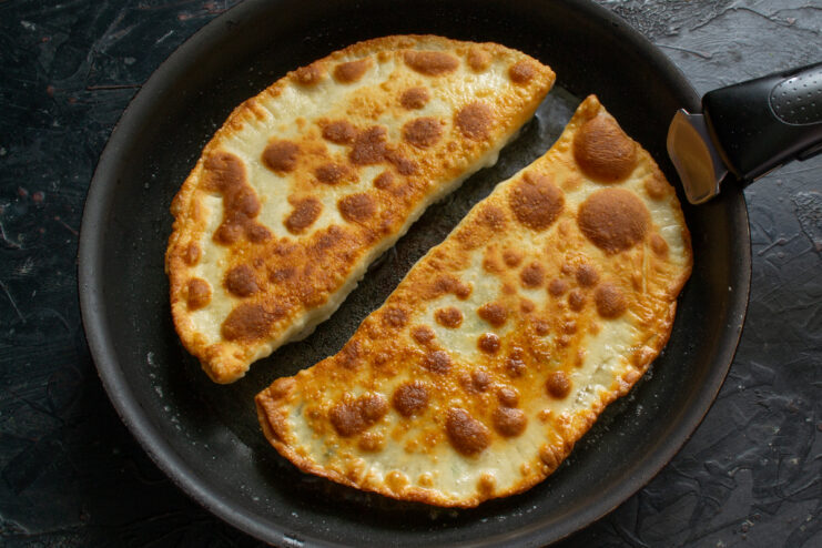 Golden Crust Flipped golden khachapuri frying on the second side