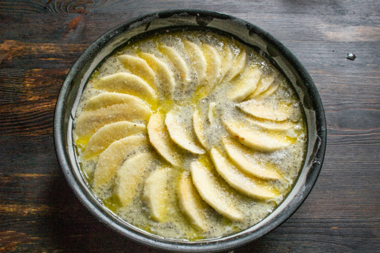 Brushing apples with butter and sugar Brushing sliced apples with butter and sprinkling sugar on top of the cake
