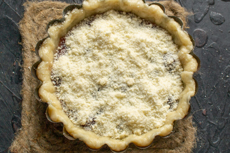Sprinkling the streusel topping Pie generously topped with a sandy crumble of butter, flour, and sugar.