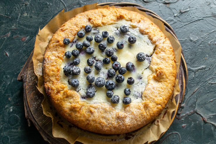 Dusting the pie with powdered sugar Cooled pie garnished with fresh berries and powdered sugar