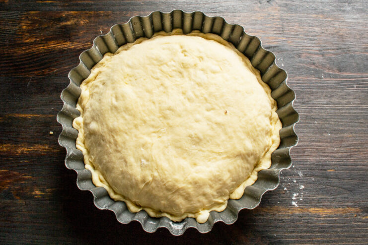 Sealing the Pie Pie covered with a second layer of dough in a metal baking pan