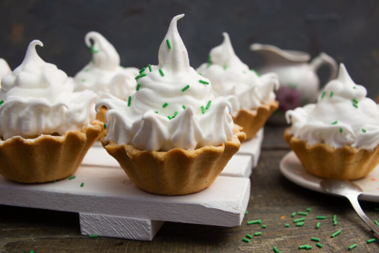 Meringue cream tartlets with green sprinkles on a plate