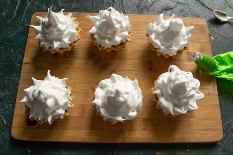 Piping Meringue Cream Piping fluffy meringue cream onto tartlets with a star nozzle