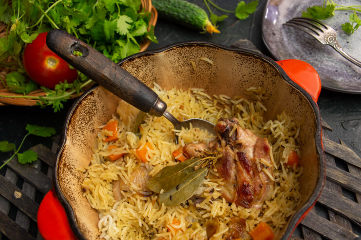 Chicken plov with Basmati rice, carrots, and herbs in a Dutch oven
