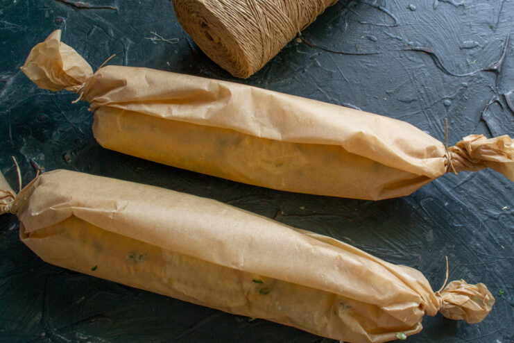 Wrapping corn in parchment Corn cobs wrapped in parchment paper tied like candies