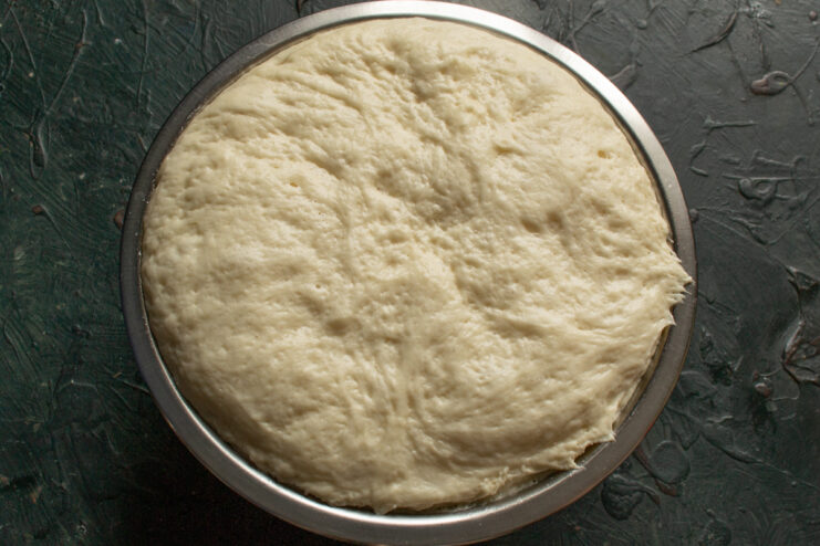 Dough after proofing Risen pizza dough sitting in a deep bowl
