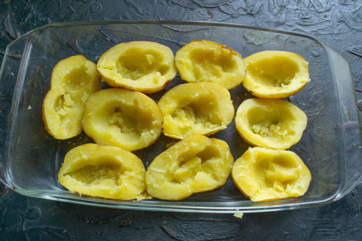 Shaping potato cups Scooping out the centers of halved baked potatoes