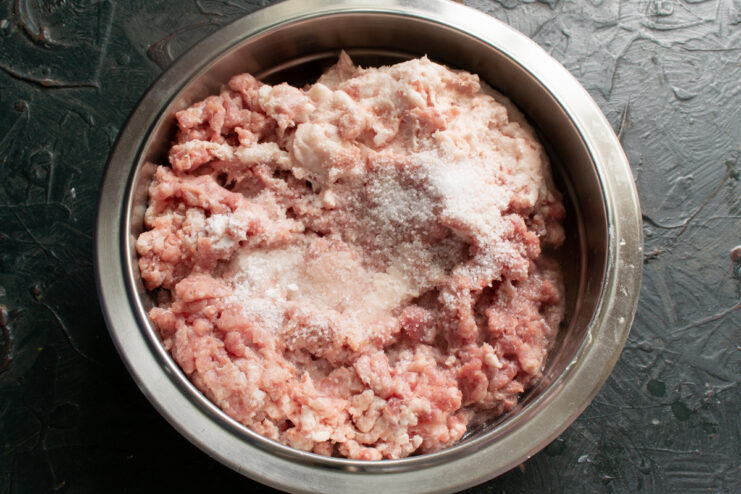 Salting the ground meat Sprinkling salt over the ground meat