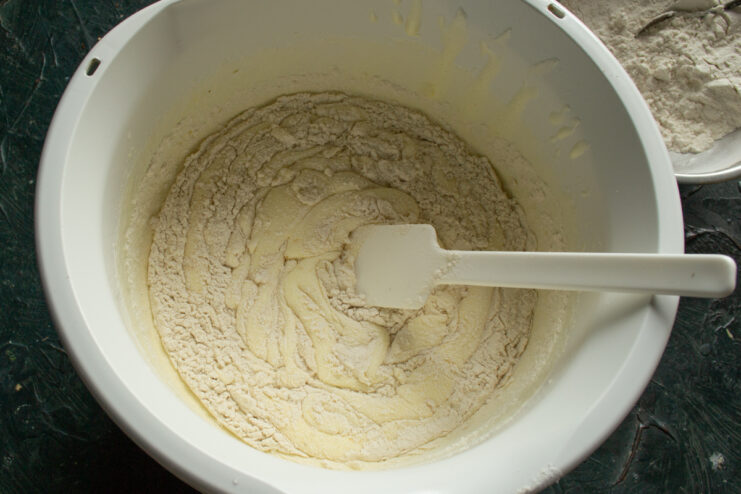 Mixing the dough base Folding flour into the wet egg base with a spatula