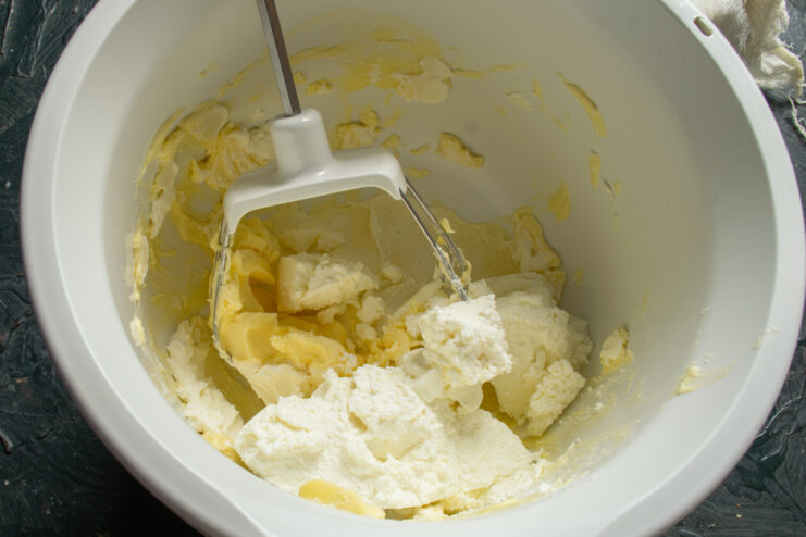 Blending the curd with the butter mixture Adding fresh curd into the whipped butter and sour cream mixture