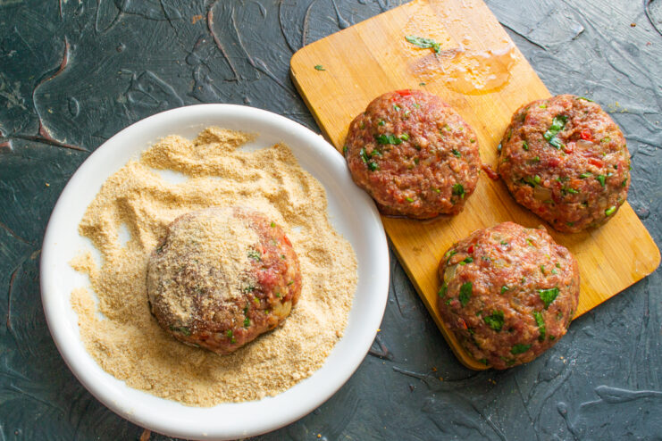 Coating in breadcrumbs Coating a raw meat patty in ground breadcrumbs