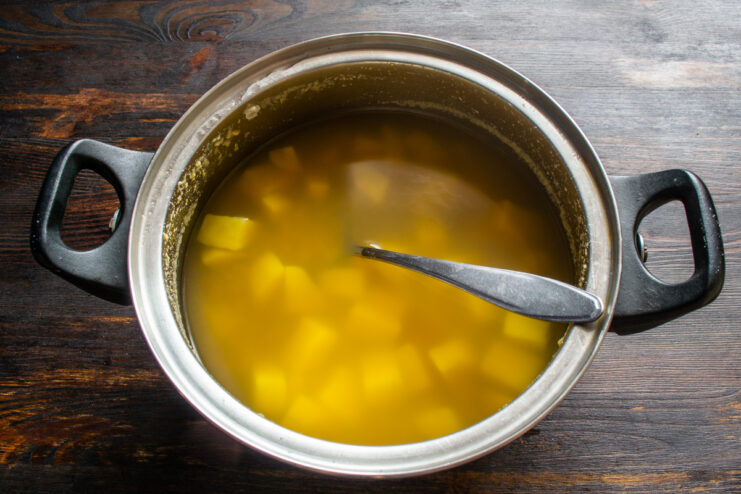 Simmering the soup base Potatoes and lentils boiling in a metal pot