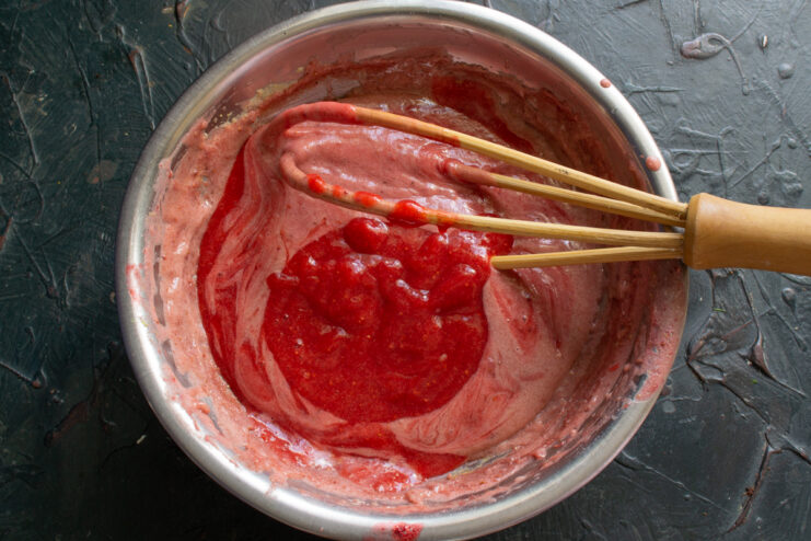 Cooking the strawberry cream Whisking strawberry custard in a metal bowl over a water bath