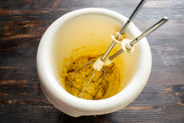 Emulsifying the sauce Blending oil into egg yolks to create a thick, creamy sauce