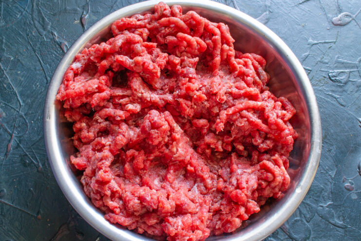 Ground Beef Mixture Freshly ground beef in a stainless steel mixing bowl