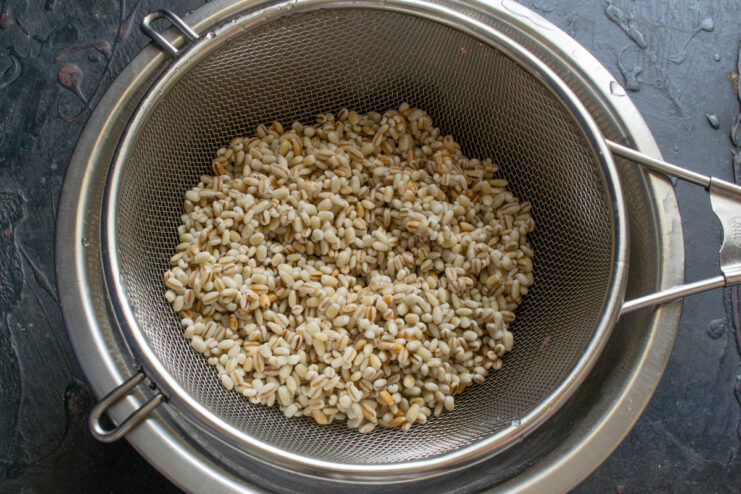Rinsing the grains Rinsed pearl barley draining in a metal fine-mesh strainer