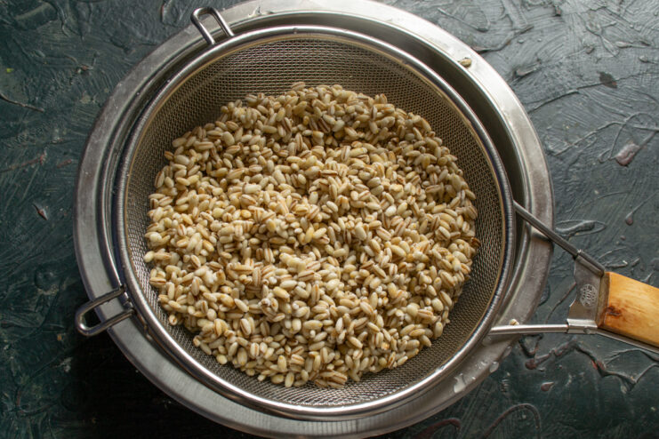 Preparing the grains Washed pearl barley draining in a fine metal strainer