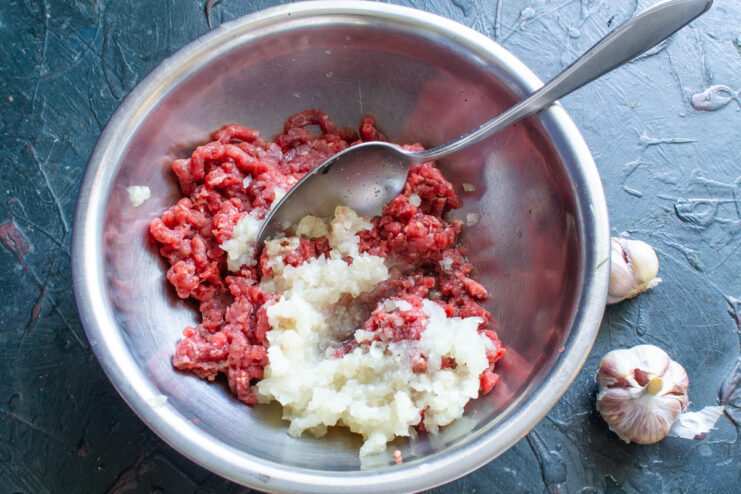 Adding Garlic Crushed garlic added to the ground meat mixture