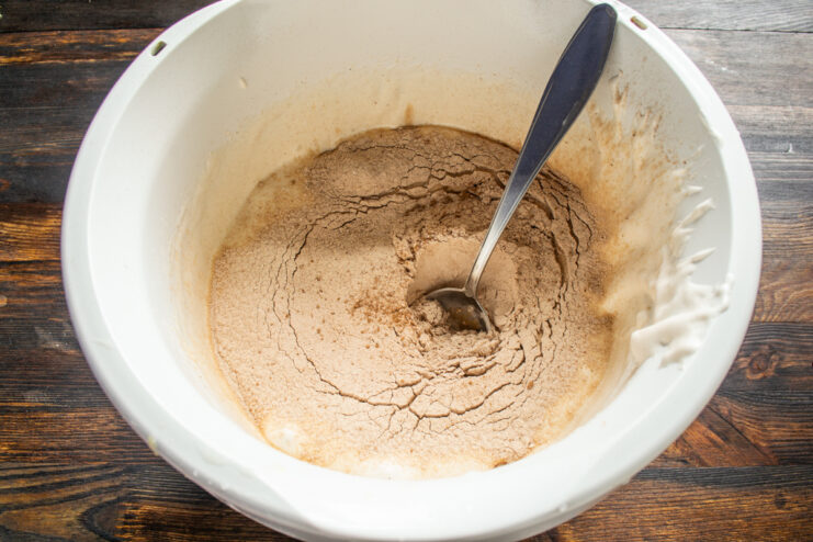 Sifting the dry ingredients Sifting cocoa and flour mixture into the whipped eggs in a bowl.