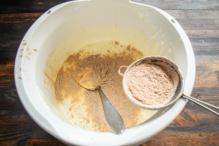 Adding Flour to Batter Sifting dry cocoa and flour mixture into whipped eggs