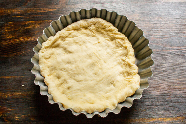 Forming Pie Base Rolled-out dough pressed into the bottom of a round baking dish