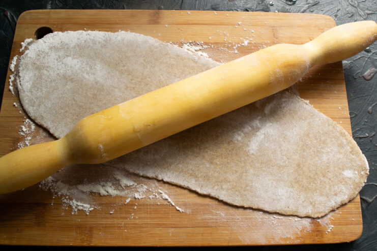Rolling out the rye dough Rolling out the rye dough thinly on a floured board using a wooden rolling pin