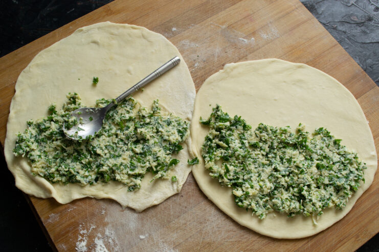 Adding the Filling Spreading cheese filling onto one half of the rolled out dough