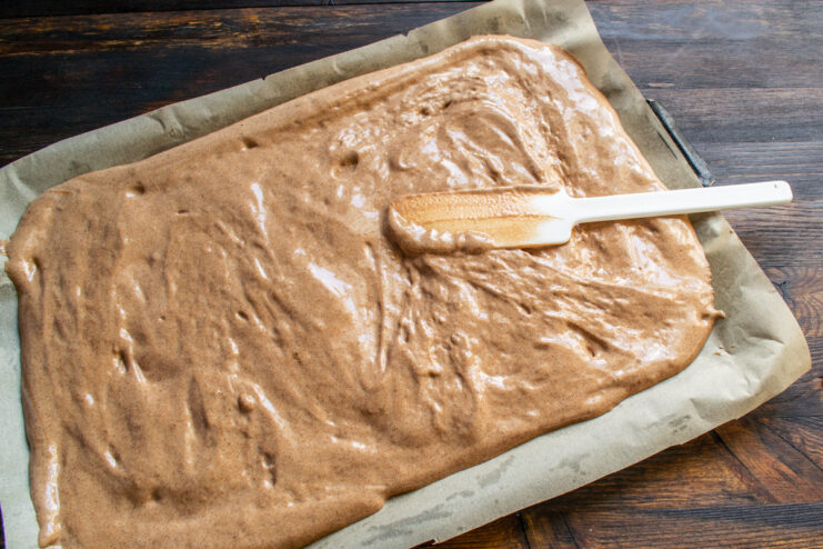 Spreading the Batter Chocolate batter spread evenly on a parchment-lined baking sheet