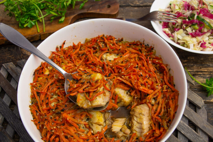 Plated ginger and sesame marinated fish covered in vibrant vegetables.