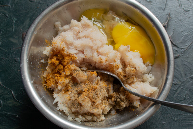 Preparing the Minced Fish Mixing minced fish with egg and spices in a bowl