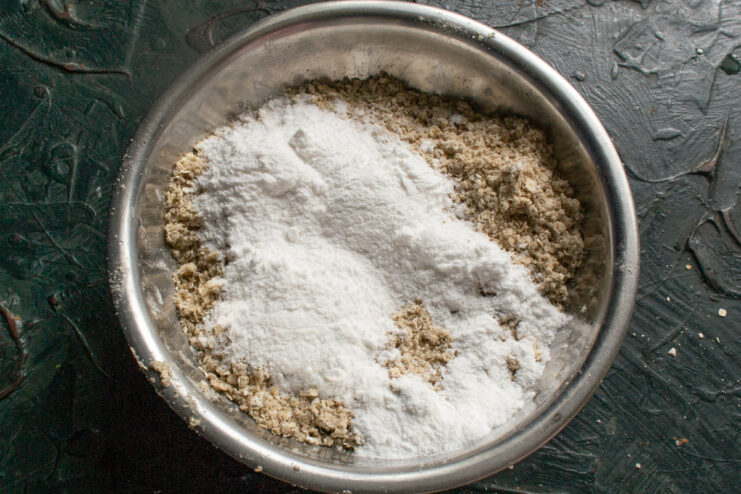 Adding powdered sugar Sifted powdered sugar on top of the crumbly butter and flour mixture