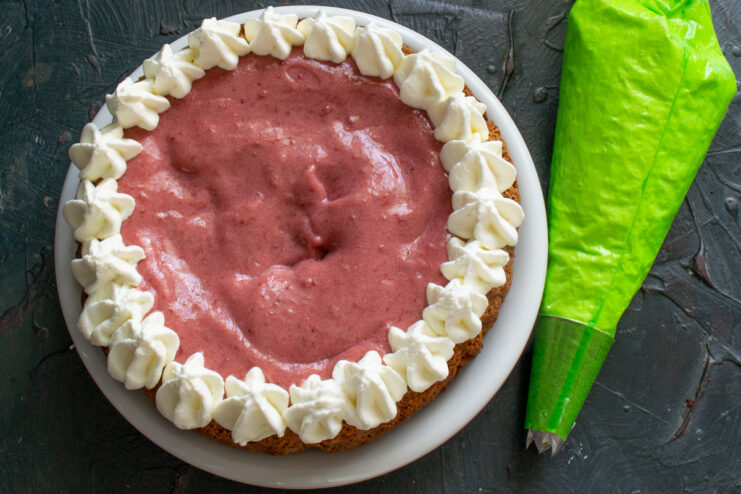 Applying the filling Assembling the cake with strawberry filling and a piped whipped cream border