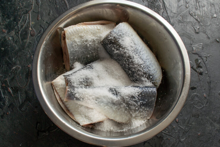 Dry curing the fish Herring halves generously coated in a mixture of coarse sea salt and sugar