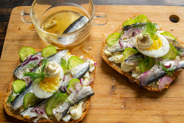 Garnishing the fish sandwich Served open-faced sandwiches with Baltic herring and red onion