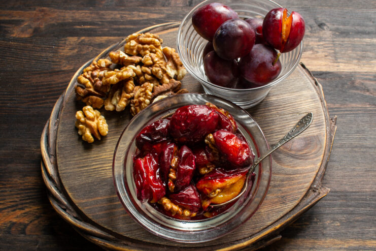 Elegant serving of baked stuffed plums with walnuts alongside fresh fruits