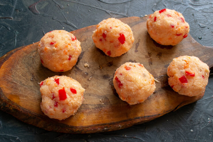 Shaped raw fish meatballs on an oiled cutting board